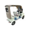 Rear angled view of beige electric tricycle with covered cabin and passenger seating