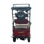 Rear view of red electric tricycle with spare wheel and passenger seating setup