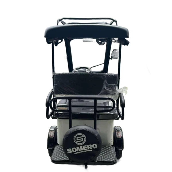 Rear view of white solar electric tricycle with passenger seating and roof mounted solar panel